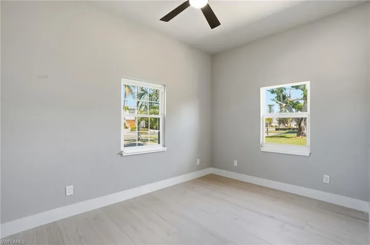 Unfurnished room featuring light wood-style floors and a ceiling fan - Virtually Edited Image