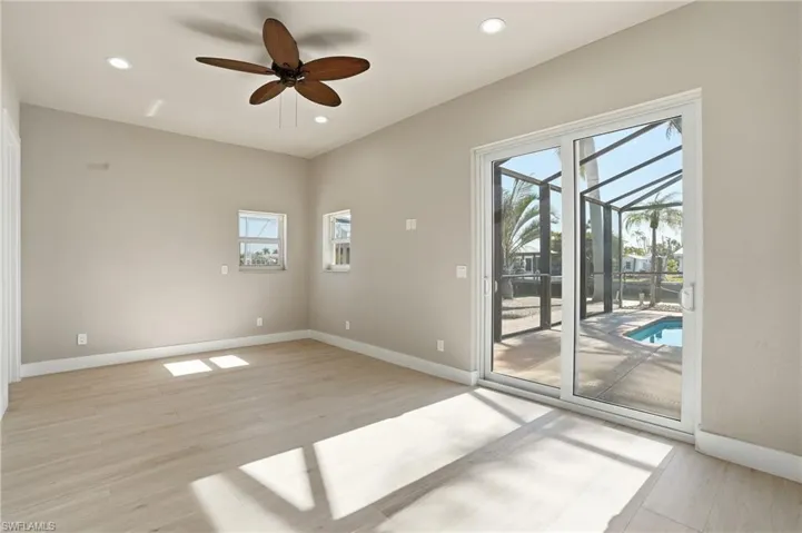 Empty room with a sunroom, a ceiling fan, light wood-style flooring, and recessed lighting - Virtually Edited Image