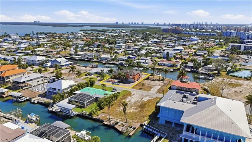 Aerial overview of property's location featuring a nearby body of water, skyline, and nearby suburban area - Virtually Edited Image