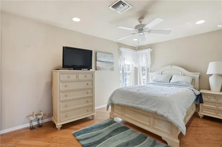 Bedroom with a ceiling fan, light wood-style floors, and recessed lighting - Virtually Edited Image