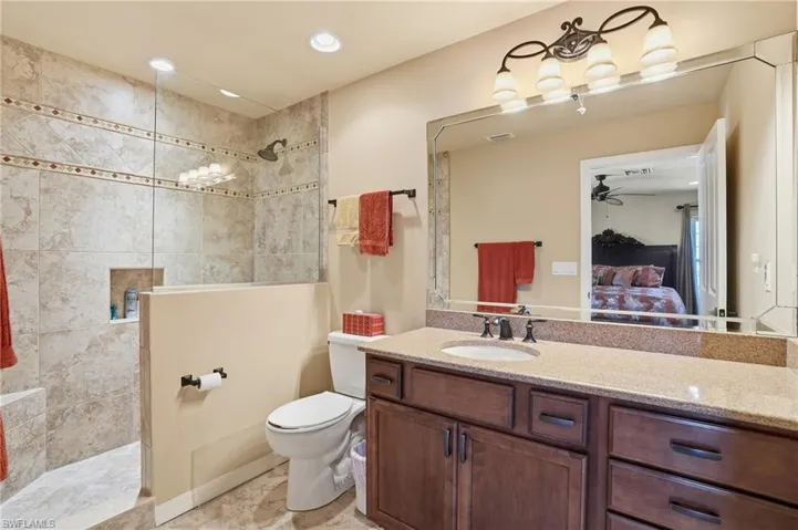 Full bathroom featuring a walk in shower, vanity, a ceiling fan, connected bathroom, and recessed lighting - Virtually Edited Image