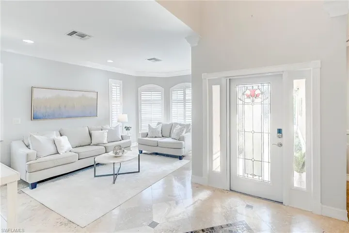 Welcoming light and bright foyer with glass entry custom doors, travertine floors throughout, crown molding and custom trim.  Every square inch of this home has been beautifully touched by upgrades and tasteful fixtures.
