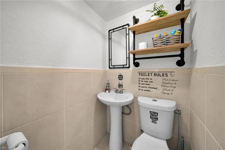 Pedestal sink with chrome faucet, complemented by a white toilet