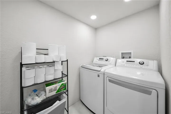 Dedicated laundry area featuring a white top-load washing machine and a white front-load dryer
