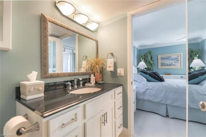 Bathroom featuring hardwood / wood-style floors, crown molding, and vanity