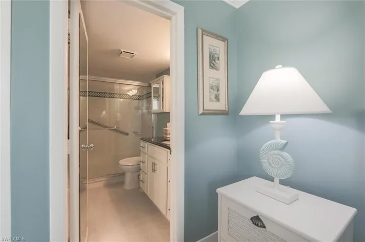 Bathroom with hardwood / wood-style flooring, toilet, vanity, and a shower with shower door