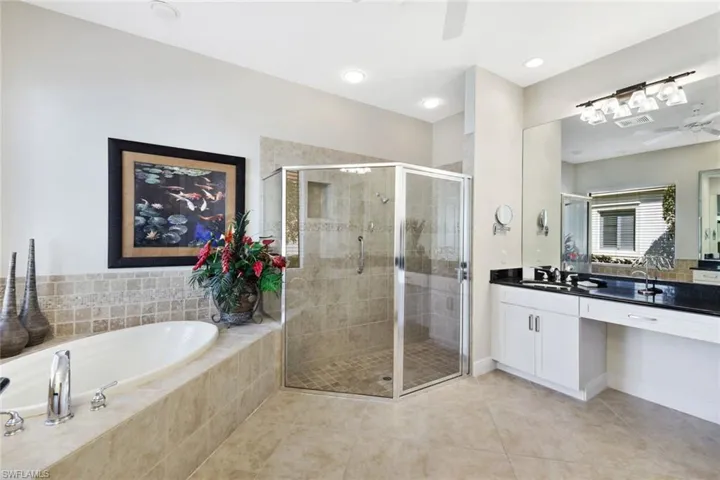 Bathroom featuring vanity, ceiling fan, a garden tub, light tile patterned floors, and a stall shower
