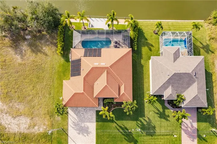 Aerial View of the House with Tiled Roof, Solar Panels, Pool, Dock & Canal!