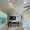 Bedroom with a wall unit AC and lofted ceiling