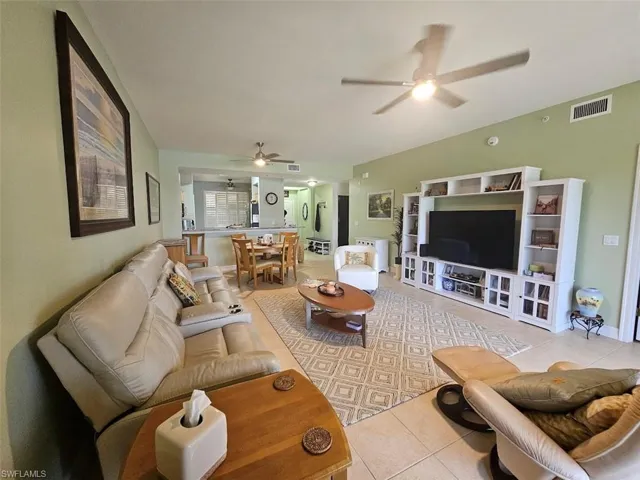 Living area with light tile patterned floors and ceiling fan