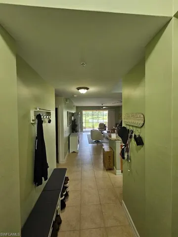 Hall featuring baseboards and light tile patterned floors
