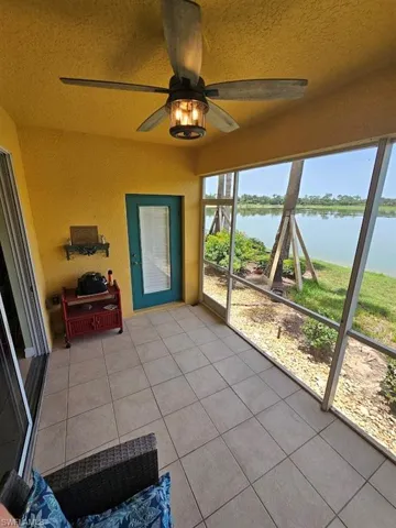 Unfurnished sunroom featuring ceiling fan and a water view