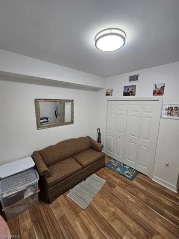 Living area featuring dark wood-style floors and baseboards
