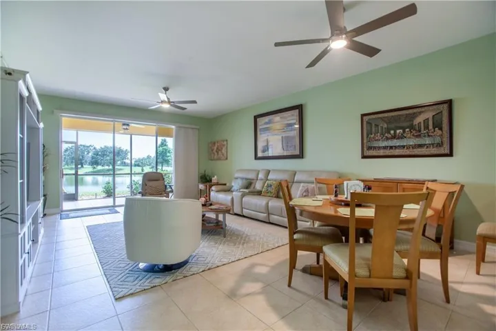 Dining area with a water view, ceiling fan, and light tile patterned floors
