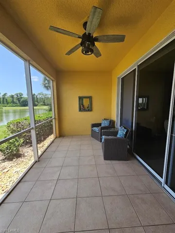Unfurnished sunroom with a ceiling fan and a water view