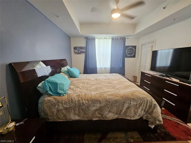 Bedroom featuring a tray ceiling and ceiling fan