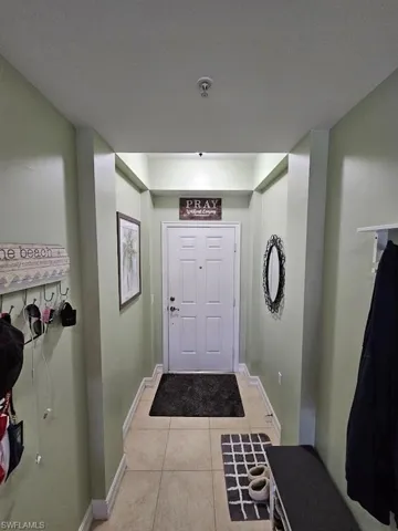 Doorway with baseboards and tile patterned floors