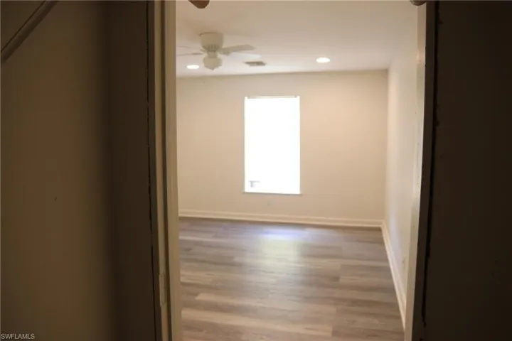 Spare room featuring dark wood-type flooring, ceiling fan, and recessed lighting