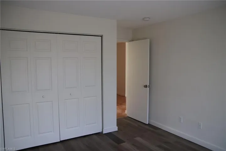 Unfurnished bedroom with dark wood finished floors and a closet