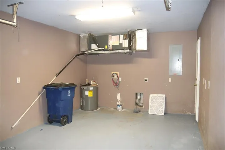 Garage featuring electric panel and water heater