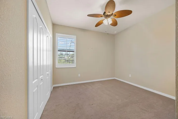 Unfurnished bedroom featuring baseboards, carpet floors, a ceiling fan, and a closet