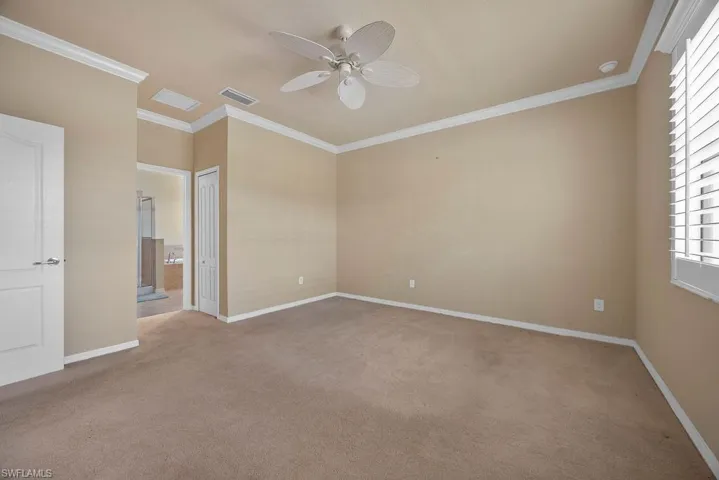 Unfurnished bedroom featuring visible vents, light colored carpet, and crown molding
