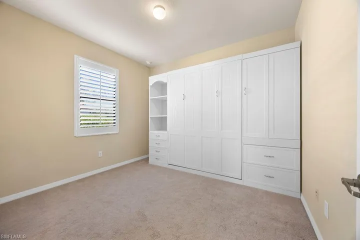Unfurnished bedroom with carpet flooring and baseboards