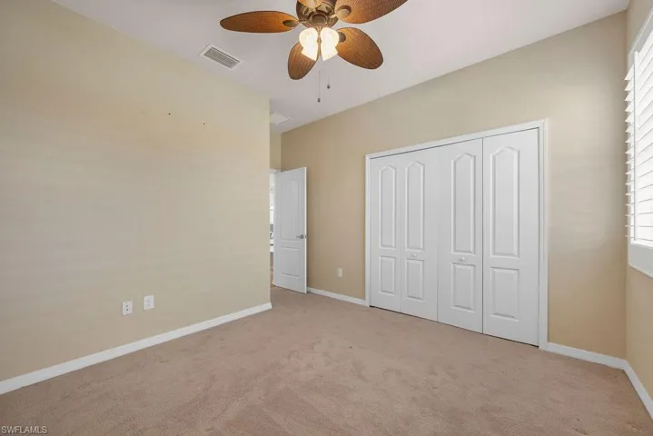 Unfurnished bedroom featuring a closet, visible vents, baseboards, and light carpet