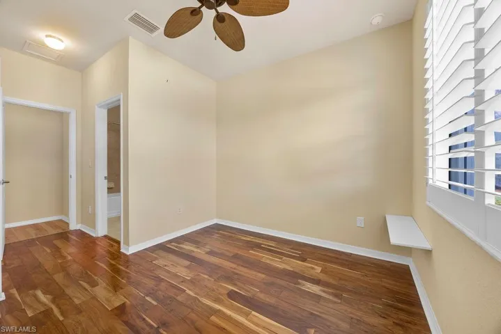 Bedroom featuring wood finished floors, baseboards, a ceiling fan, and visible vents