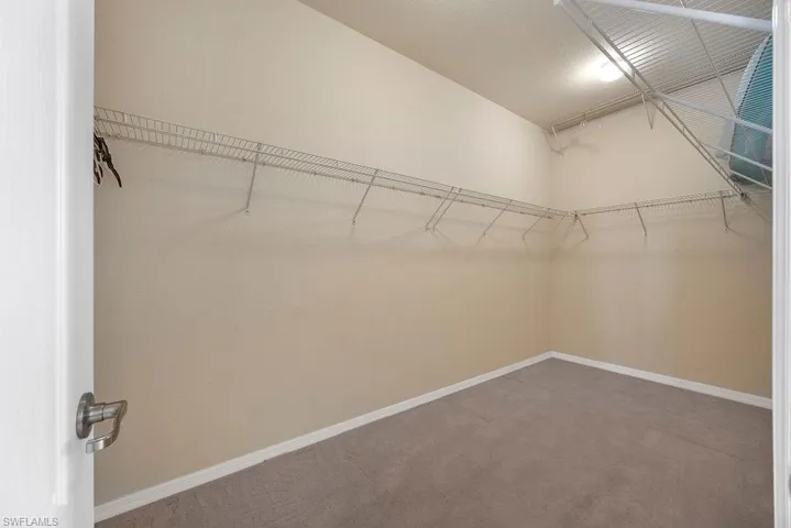 Primary Bedroom Walk in closet with carpet floors