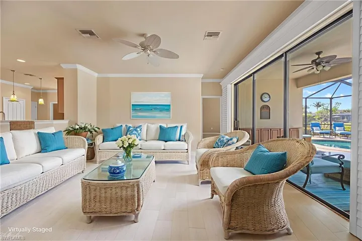 Living area with a ceiling fan, ornamental molding, a sunroom, and light wood-type flooring