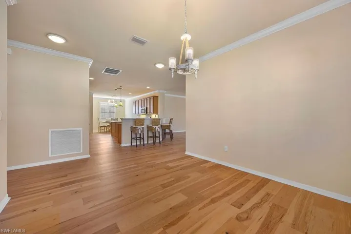 Dining area featuring visible vents, baseboards, and a notable chandelier
