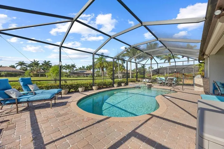 View of pool with a pool with connected hot tub, a lanai, and a patio