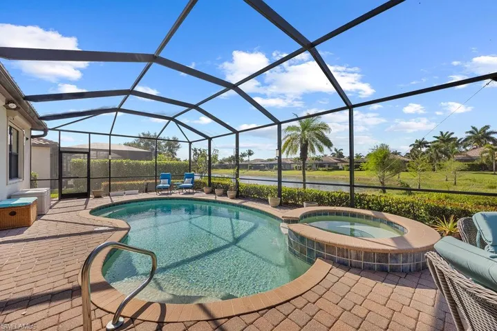 View of swimming pool with a patio area, a lanai, and a pool with connected hot tub