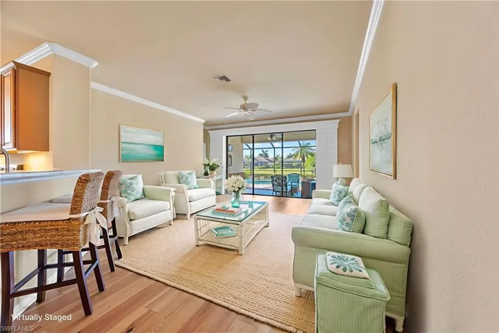 Living area featuring light wood-style floors, ornamental molding, and a ceiling fan