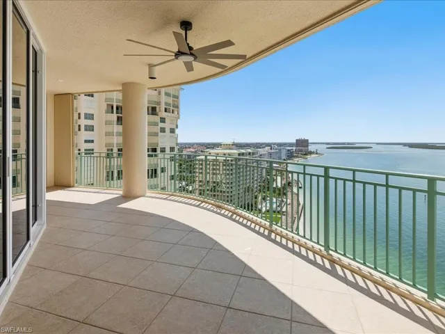 Expansive outdoor balcony with tile flooring and a curved green railing
