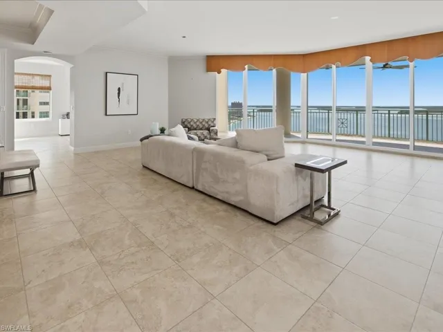 Open-concept living area with expansive floor-to-ceiling windows, showcasing panoramic waterfront scenery