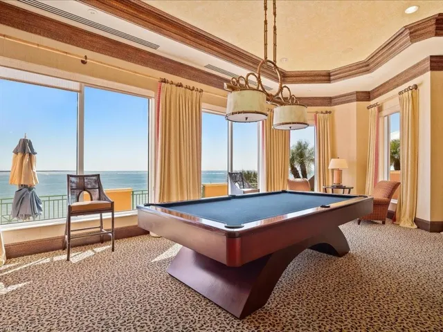 Recreation room featuring a water view, ornamental molding, and billiards table