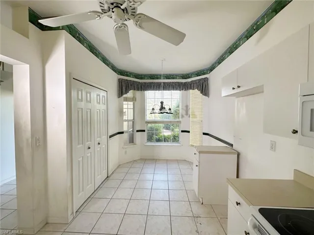 Kitchen featuring ceiling fan, white cabinetry, and light tile patterned floors