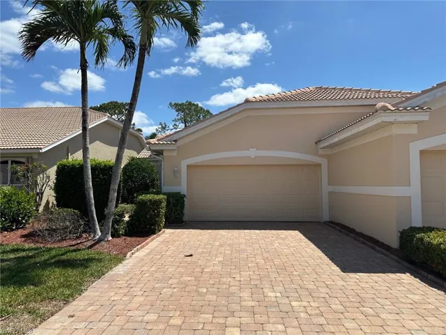 View of front of house featuring stucco siding, decorative driveway, a garage, and a tile roof