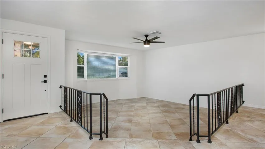 Foyer featuring ceiling fan and baseboards