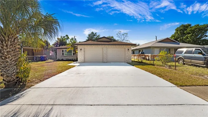 Single story home with concrete driveway, a garage, and stone siding