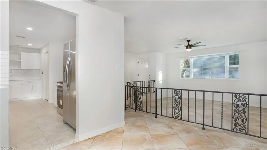 Corridor with an upstairs landing, light tile patterned floors, and recessed lighting