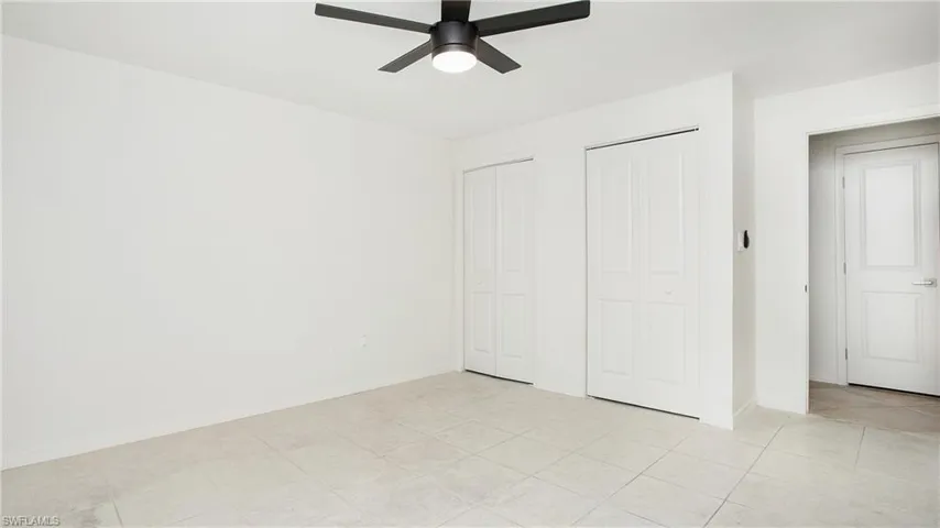 Unfurnished bedroom featuring multiple closets and a ceiling fan