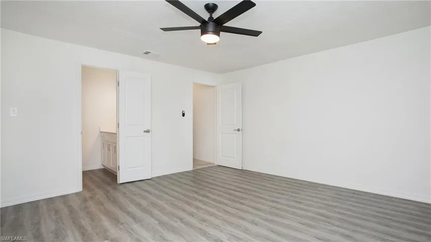 Empty room with a ceiling fan and light wood-style floors
