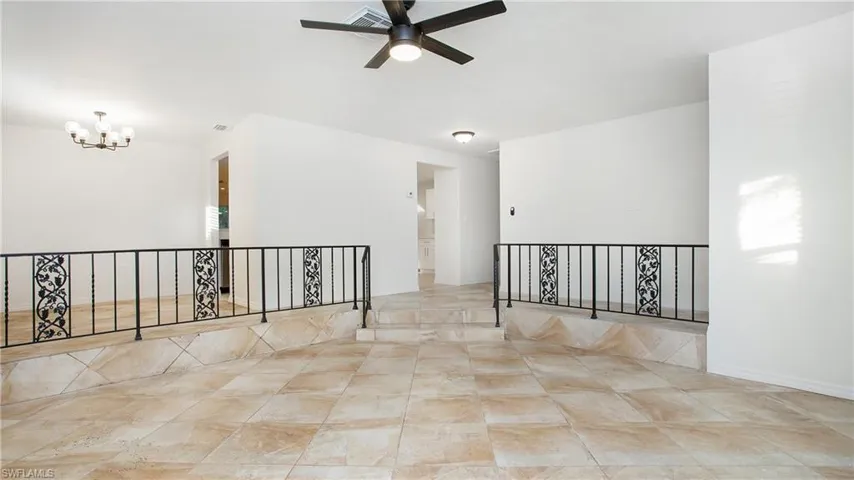 Spare room with a chandelier and a ceiling fan