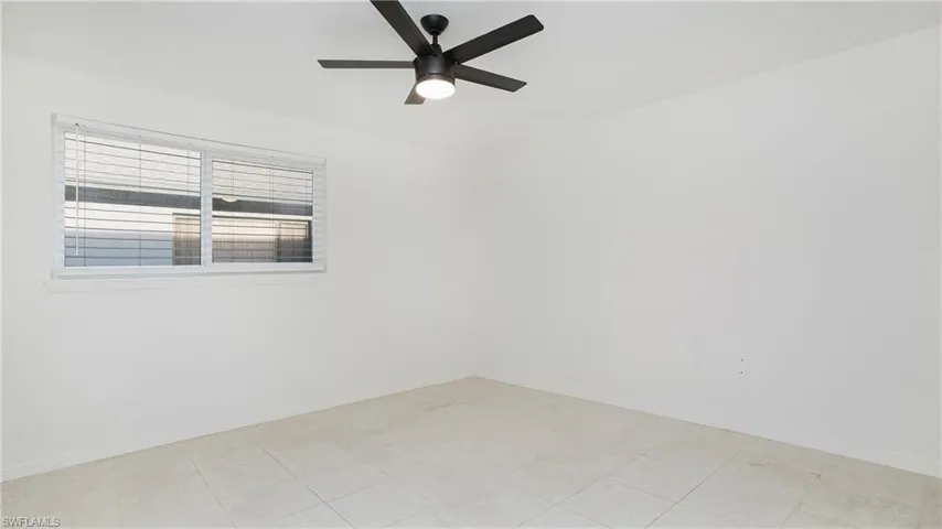 Empty room with ceiling fan and baseboards