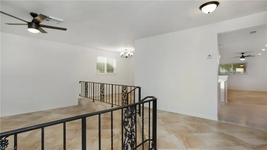 Corridor featuring an upstairs landing, a chandelier, and light tile patterned floors