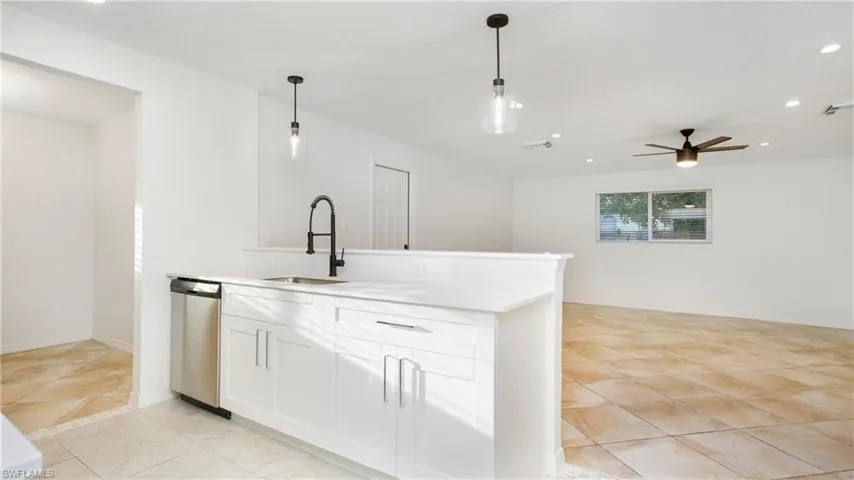 Kitchen with dishwasher, recessed lighting, hanging light fixtures, a ceiling fan, and white cabinets