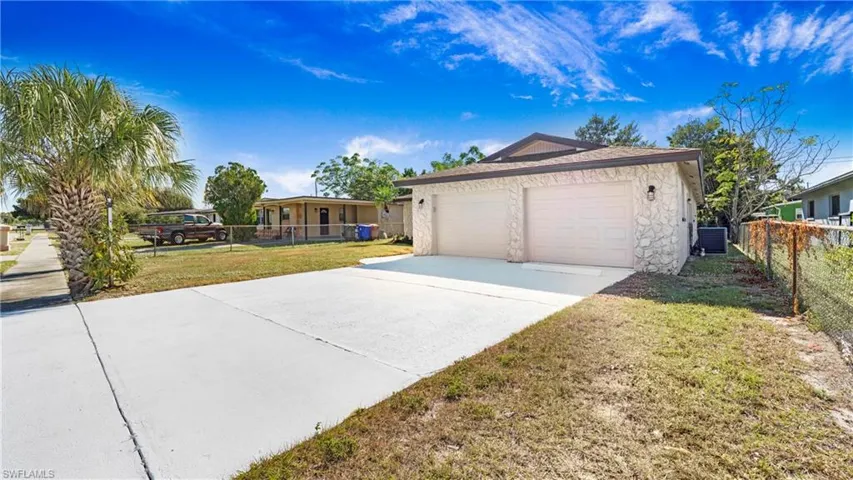 Ranch-style home featuring a garage and concrete driveway